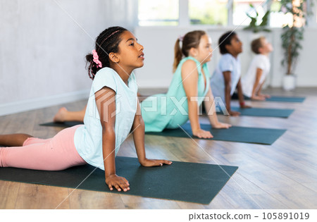 Preteen Children practicing yoga in Urdhva Mukha Shvanasana in gym Preteen Children practicing yoga in Urdhva Mukha Shvanasana in gym 105891019