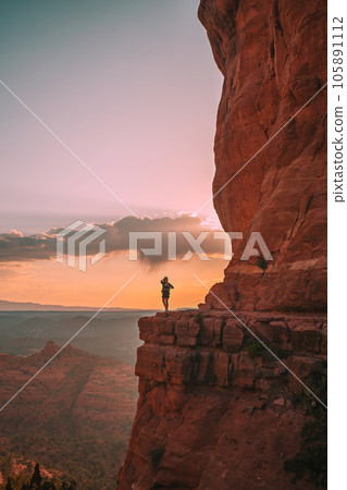Young hiker woman on the edge of a cliff at Cathedral Rock in Sedona, Arizona. View from Scenic Cathedral Rock in Sedona with blue sky in Arizona Young hiker woman on the edge of a cliff at Cathedral Rock in Sedona, Arizona. View from Scenic Cathedral Rock in Sedona with blue sky in Arizona 105891112