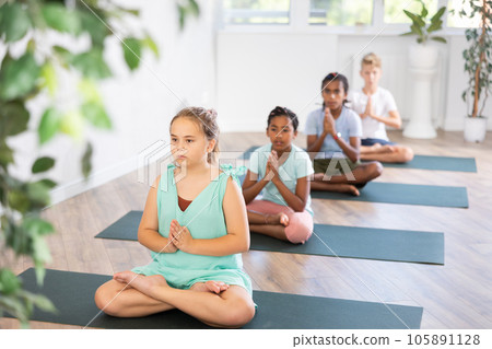 Girl perform lotus pose with load on lateral muscles. Comprehensive hatha yoga class, mini group 105891128