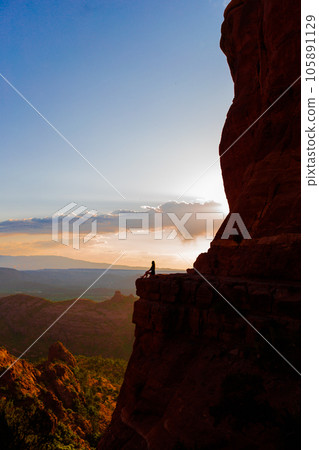 Young hiker woman on the edge of a cliff at Cathedral Rock in Sedona, Arizona. View from Scenic Cathedral Rock in Sedona with blue sky in Arizona Young hiker woman on the edge of a cliff at Cathedral Rock in Sedona, Arizona. View from Scenic Cathedral Rock in Sedona with blue sky in Arizona 105891129