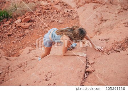 Young girl climbs in red mountains on trail  105891138