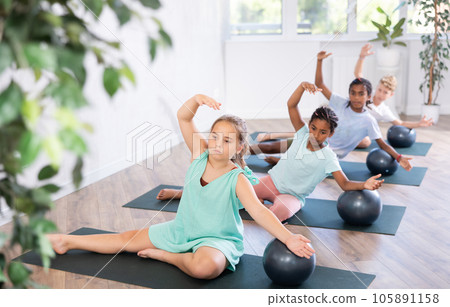 Group of multiethnic children doing pilates with soft ball 105891158