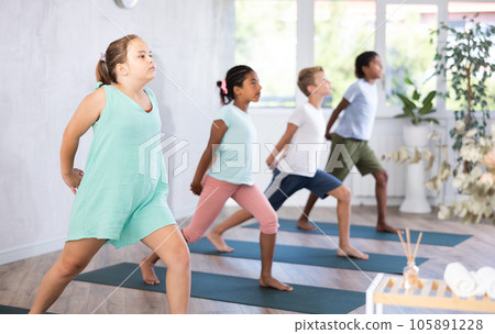 Children doing stretching workout for body flexibility in yoga studio Children doing stretching workout for body flexibility in yoga studio 105891228