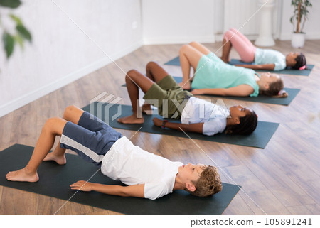 Kids yoga exercise - setu bandha sarvangasana. 105891241