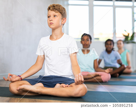 Young boy doing yoga in group of children Young boy doing yoga in group of children 105891258