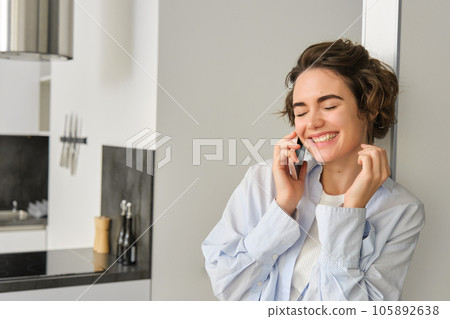 Image of happy woman talking on mobile phone, having a chat, using smartphone, laughing and smiling, calling from home Image of happy woman talking on mobile phone, having a chat, using smartphone, laughing and smiling, calling from home 105892638