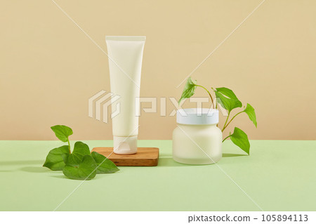 On the brown background, plastic tube and jar displayed with fish mint leaves. Advertising scene for cosmetics with ingredients from fish mint, which has many good benefits for skin and health On the brown background, plastic tube and jar displayed with fish mint leaves. Advertising scene for cosmetics with ingredients from fish mint, which has many good benefits for skin and health 105894113