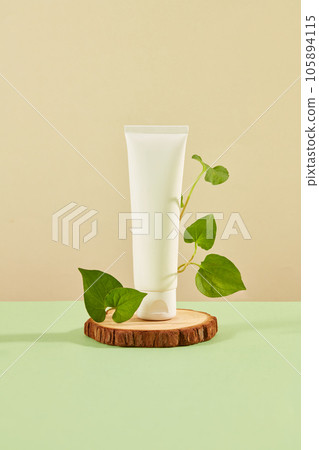 Front view of white plastic bottle unbranded with fresh fish mint leaves decorated on brown background. Mockup for advertising cosmetic extracted from fish mint with space for design packaging Front view of white plastic bottle unbranded with fresh fish mint leaves decorated on brown background. Mockup for advertising cosmetic extracted from fish mint with space for design packaging 105894115