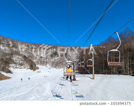 Ski resort in early spring when the snow begins to melt and the surface of the mountain begins to appear, lift view (Ryuoo Ski Park, Nagano Prefecture) 105894375