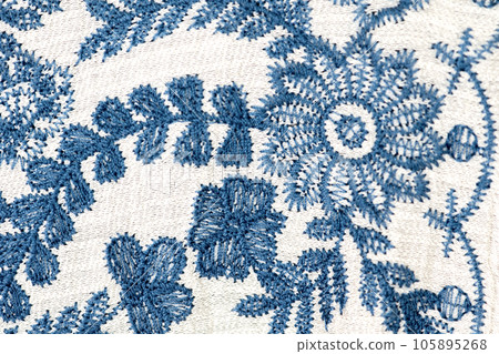 Embroidered blue flowers on a white background. Embroidered blue flowers on a white background. 105895268