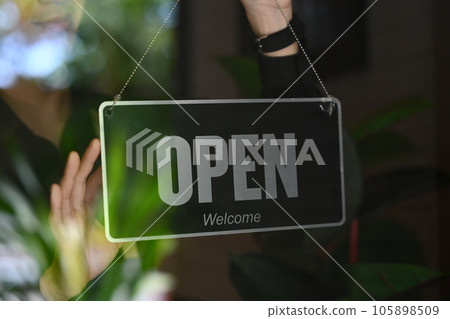 Man coffee shop or restaurant owner turning Open sign on the entrance door Man coffee shop or restaurant owner turning Open sign on the entrance door 105898509