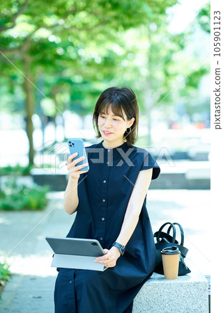 Young woman operating a tablet PC outdoors Young woman operating a tablet PC outdoors 105901123
