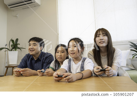 A young family with twins enjoying the game, a close family image 105901207