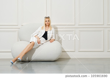 Beautiful woman rests in big soft chair Beautiful woman rests in big soft chair 105901690