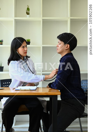 Image of female pediatrician using stethoscope to examine breathing and heartbeat of male patient 105902166