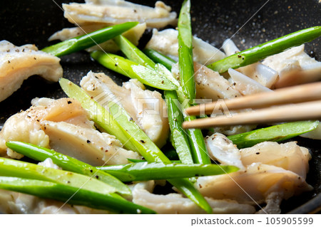 A cooking scene in which chicken cartilage (Yagen cartilage) and garlic sprouts are fried in a frying pan. A cooking scene in which chicken cartilage (Yagen cartilage) and garlic sprouts are fried in a frying pan. 105905599