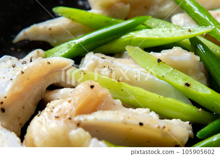 A close-up of a cooking scene in which chicken cartilage (yagen cartilage) and garlic sprouts are fried in a frying pan. 105905602