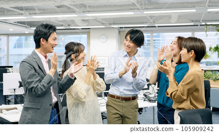 Smiling business group wearing office casual applause Smiling business group wearing office casual applause 105909242