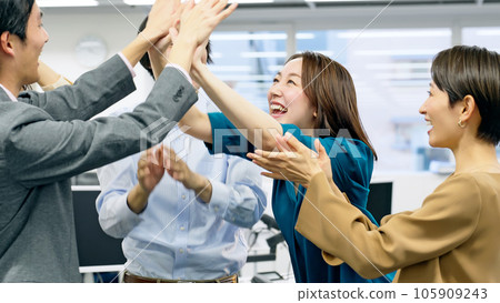 A group of office workers giving a high touch in the office A group of office workers giving a high touch in the office 105909243