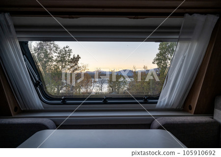 Sunset Autumn season in Abisko through a caravan window with Lake Tornetraesk in background Swedish Lapland Sweden 105910692