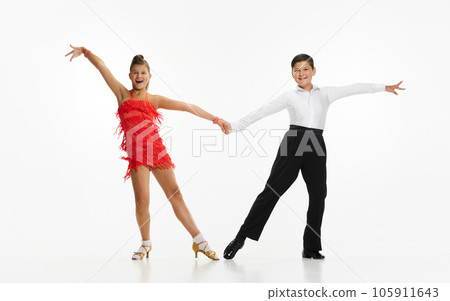 Talented, beautiful, artistic children, boy and girl in stage costumes dancing retro style dance against white studio background 105911643