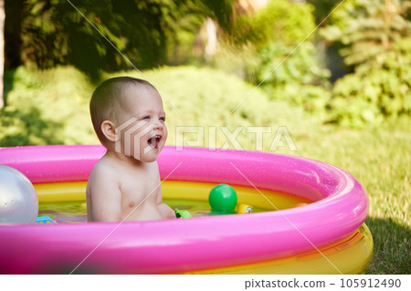 cute baby girl swimming in kid inflatable pool cute baby girl swimming in kid inflatable pool 105912490