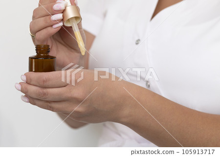 Closeup Real Beautician Applies Multi Recovery Skin Serum, Hyaluronic On Skin, Holding Brown Bottle With Cream And Pipette. Skin Hydration, Repair. Cosmetics, Beauty Concept. Body Care, Horizontal 105913717