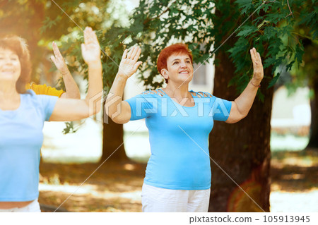 Cheerful, smiling senior people, women training outdoors in park on warm summer day. Keeping healthy and fit body Cheerful, smiling senior people, women training outdoors in park on warm summer day. Keeping healthy and fit body 105913945