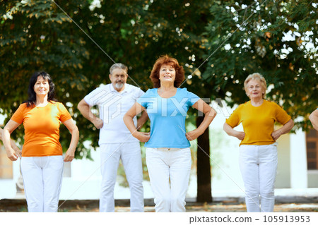 Group of senior people doing outdoor workout in city park on warm sunny morning. Keeping body fit Group of senior people doing outdoor workout in city park on warm sunny morning. Keeping body fit 105913953