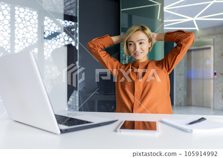 Dreamy thinking woman completed work well, successful achievement result resting and smiling at workplace sitting using laptop, hands behind head relaxing. Dreamy thinking woman completed work well, successful achievement result resting and smiling at workplace sitting using laptop, hands behind head relaxing. 105914992