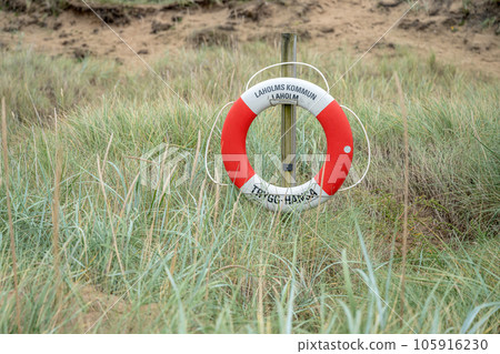 A lifebuoy sign in the dunes of laholm standing in the gras of melbystrand Sweden 105916230