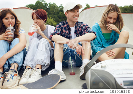 positive, relaxed teens, friends sitting on skate park, meeting together, having fun, talking positive, relaxed teens, friends sitting on skate park, meeting together, having fun, talking 105916358