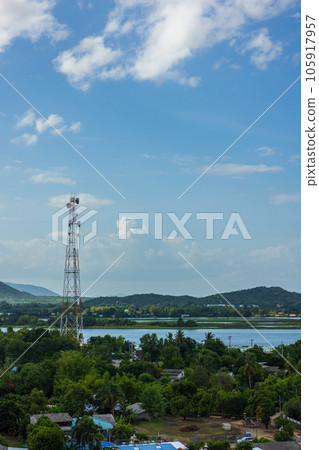 a telephone tower aerial photo shows a cell tower for a mobile phone over a rural, forested area in Thailand. 105917957