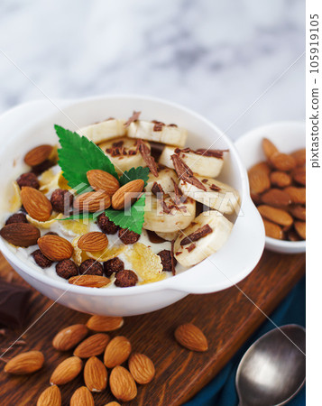 Almond banana salad with chocolate and milk in white plate. Healthy nutritious breakfast. Top view Almond banana salad with chocolate and milk in white plate. Healthy nutritious breakfast. Top view 105919105