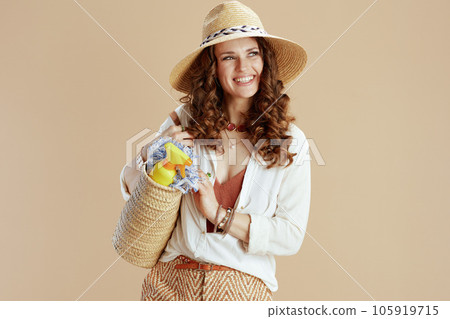 smiling elegant female in blouse and shorts against beige 105919715