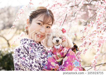 A woman who smiles while holding a dog in full bloom 105919735