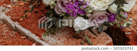 Festive wedding bouquet tied with a ribbon on a brick background. Festive wedding bouquet tied with a ribbon on a brick background. 105920741