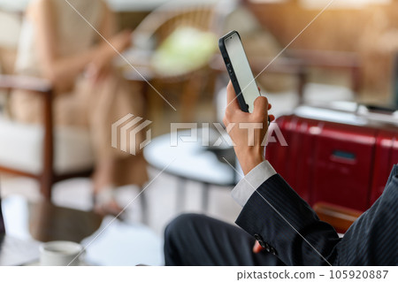 Operating a smartphone in the lounge 105920887