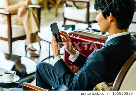 Operating a smartphone in the lounge 105920889