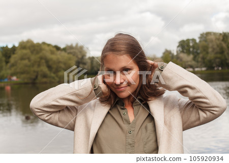 Portrait of young pretty brunette woman in park 105920934