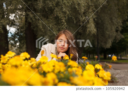 Cute woman with yellow flowers outdoor Cute woman with yellow flowers outdoor 105920942
