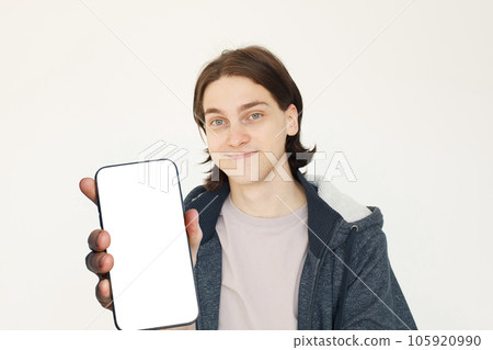 Smiling young man with big blank smartphone with empty white screen display for new Application  105920990