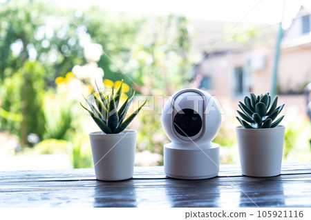 Video surveillance equipment on the table. Compact security camera for outdoor or private home security. Video surveillance equipment on the table. Compact security camera for outdoor or private home security. 105921116