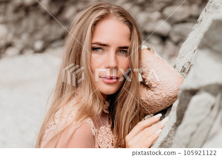 Woman summer travel sea. Happy tourist in beige dress enjoy taking picture outdoors for memories. Woman traveler posing on the beach surrounded by volcanic mountains, sharing travel adventure journey Woman summer travel sea. Happy tourist in beige dress enjoy taking picture outdoors for memories. Woman traveler posing on the beach surrounded by volcanic mountains, sharing travel adventure journey 105921122