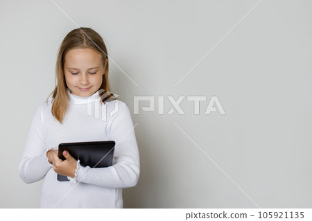 Kid with tablet gadget against white studio wall background 105921135