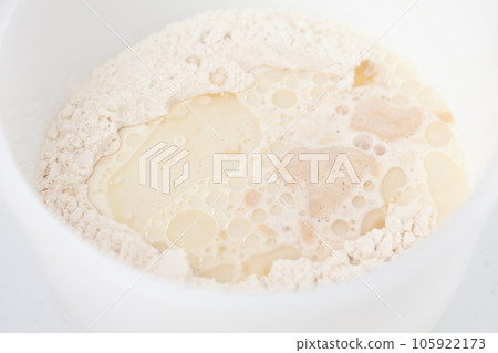 Adding leavened yeast. Home made pizza dough preparation. Pizza preparation. Adding leavened yeast. Home made pizza dough preparation. Pizza preparation. 105922173