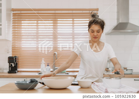 Woman checking out the food she made in the kitchen. Woman checking out the food she made in the kitchen. 105922630