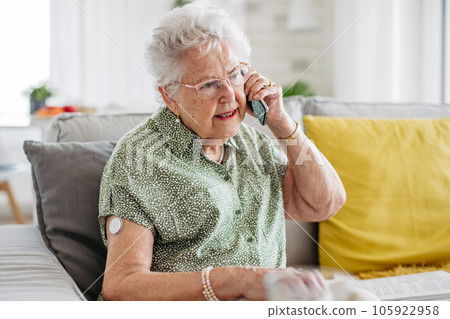 Diabetic senior patient using continuous glucose monitor to check blood sugar level at home. Diabetic senior patient using continuous glucose monitor to check blood sugar level at home. 105922958