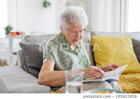 Diabetic senior patient using continuous glucose monitor to check blood sugar level at home. Diabetic senior patient using continuous glucose monitor to check blood sugar level at home. 105922959
