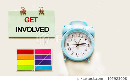 Get involved text written on sticker next to alarm clock on white background. Motivational concept 105923008